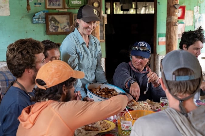 A group of gap year students eating a family-style meal together