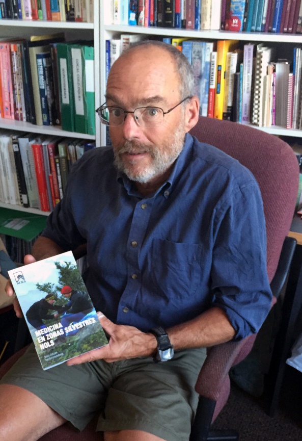 Tod Schimelpfenig holds the book Medicina en zonas silvestres