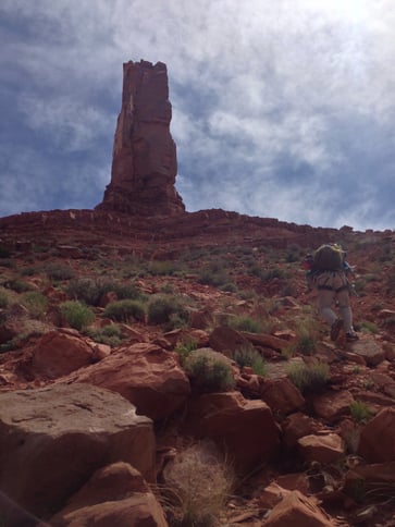 A rescuer hikes toward the base of the climb