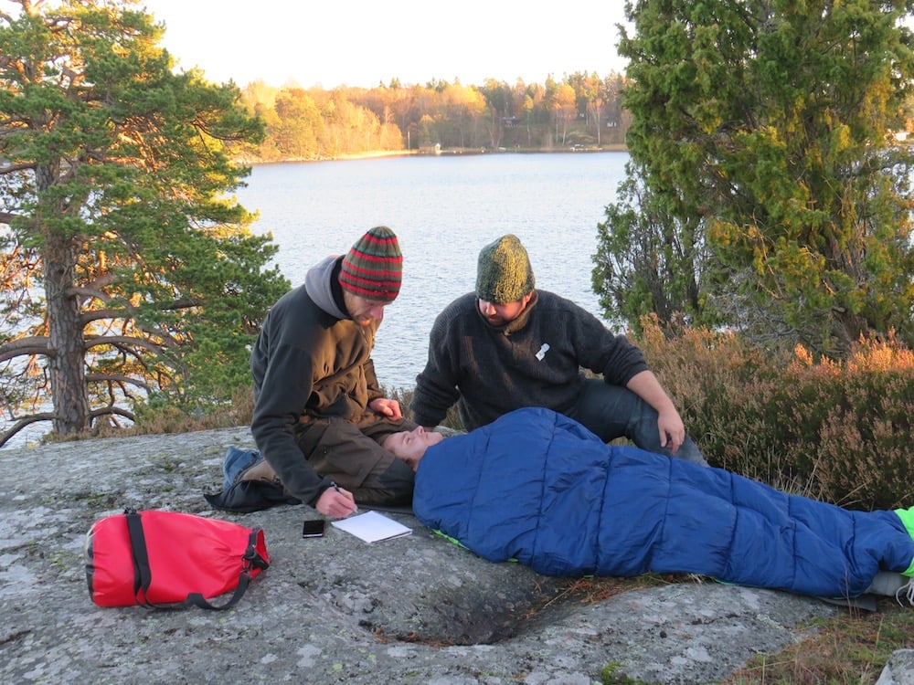 NOLS students care for a patient in a sleeping bag in a wilderness medicine scenario