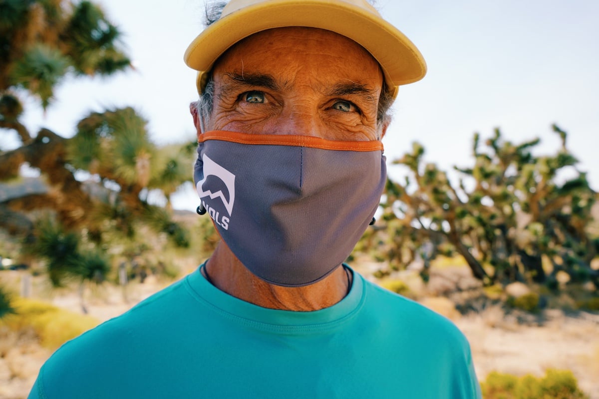 Close-up shot of a man wearing a NOLS-logo face covering