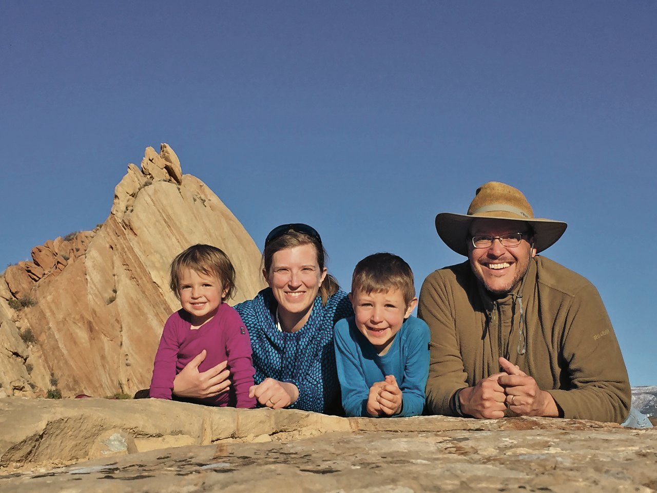 Marcio and his family smile with desert rocks in the background
