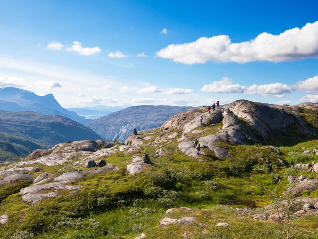 Hikers climb a rock in a mountain landscape