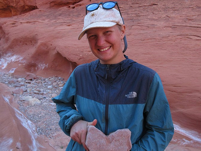 Jay Clark holding a heart shaped rock in a Utah canyon