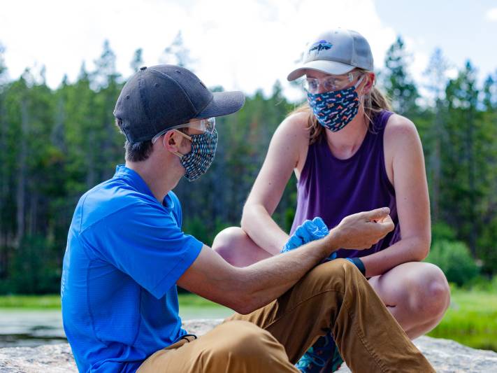 Woman takes a man's pulse during a practice scenario