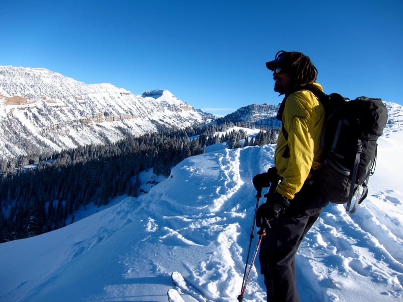 NOLS participant looks out at a snow-covered ridge while backcountry touring in the Rockies