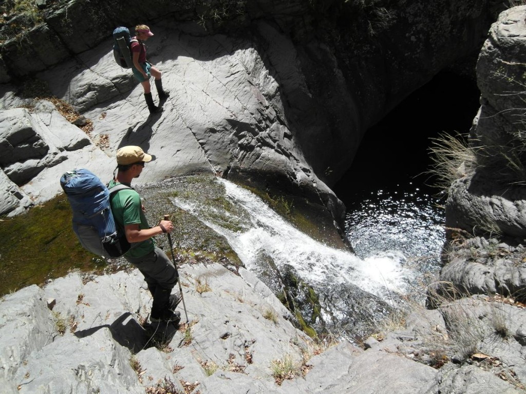 Two hikers look at waterfall on Gila River