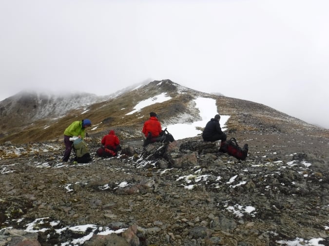 4 gap year students backpacking up a snowy mountain