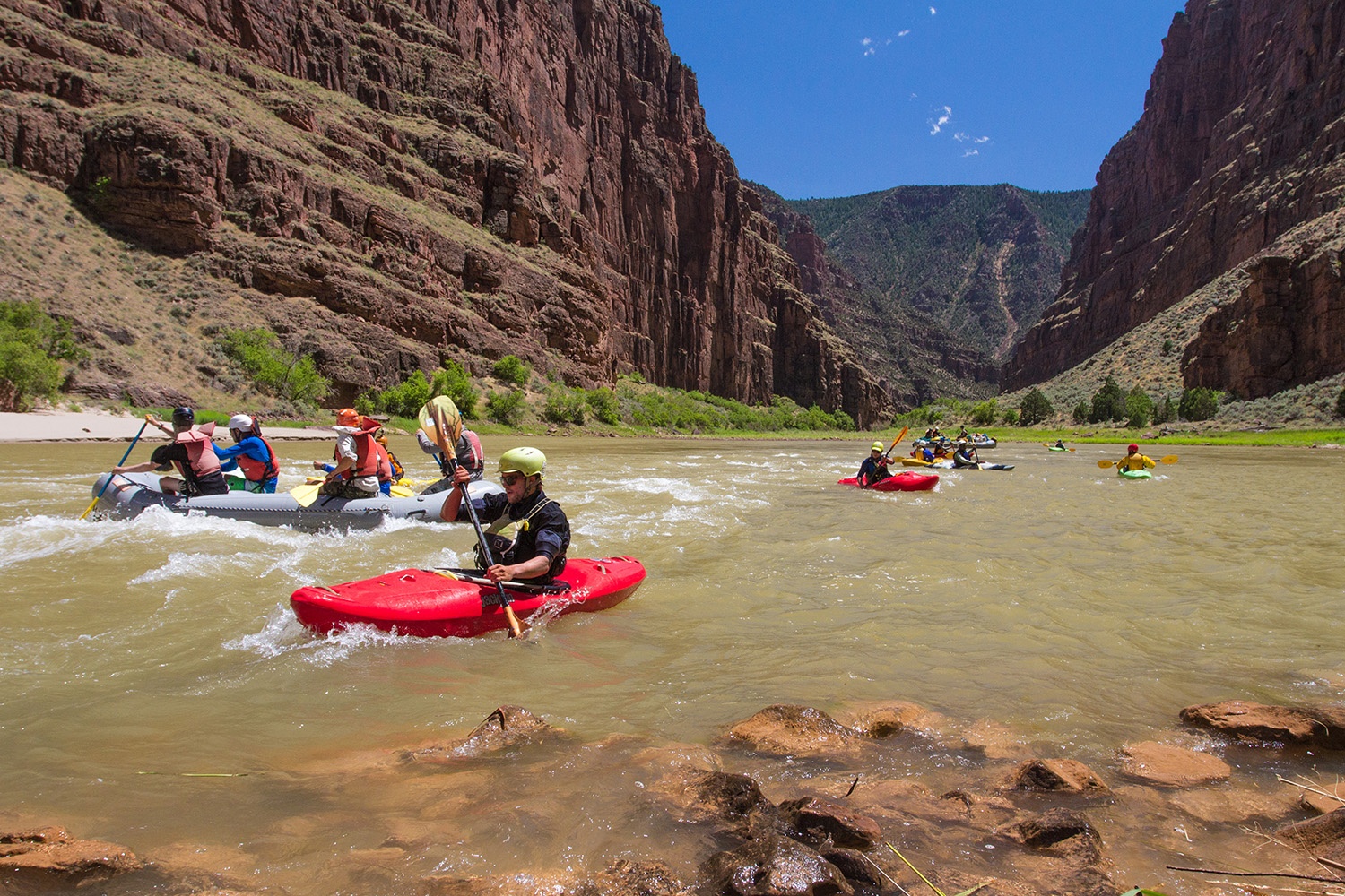 Group of NOLS students paddling rafts and kayaks