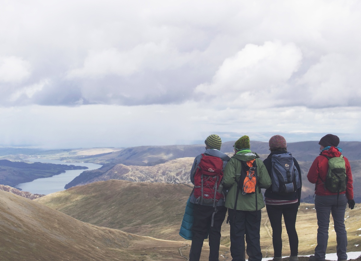 Four hikers look over scenic mountain view