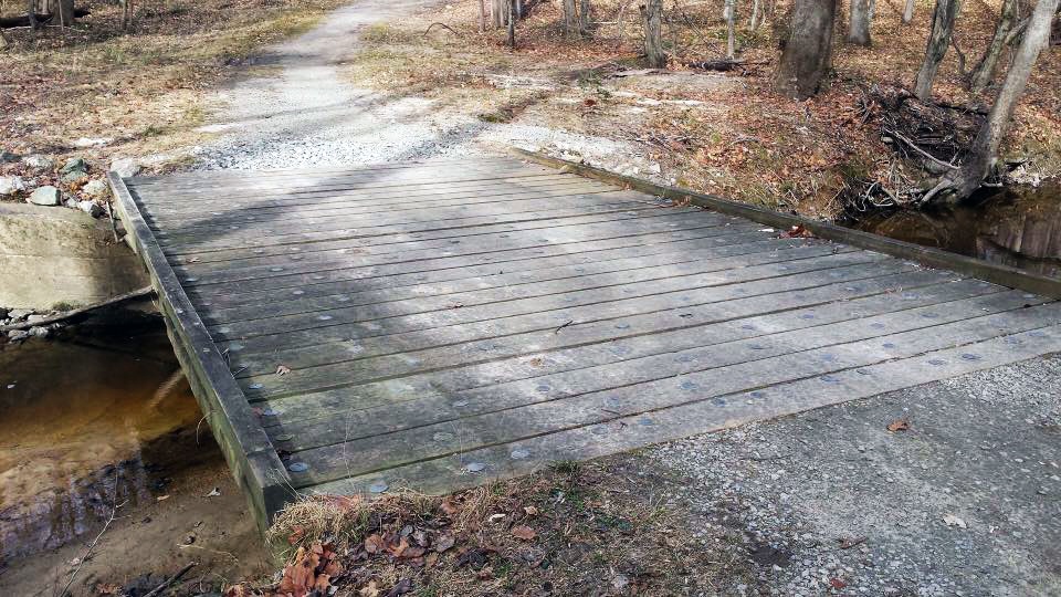 wooden bridge over a creek in the park