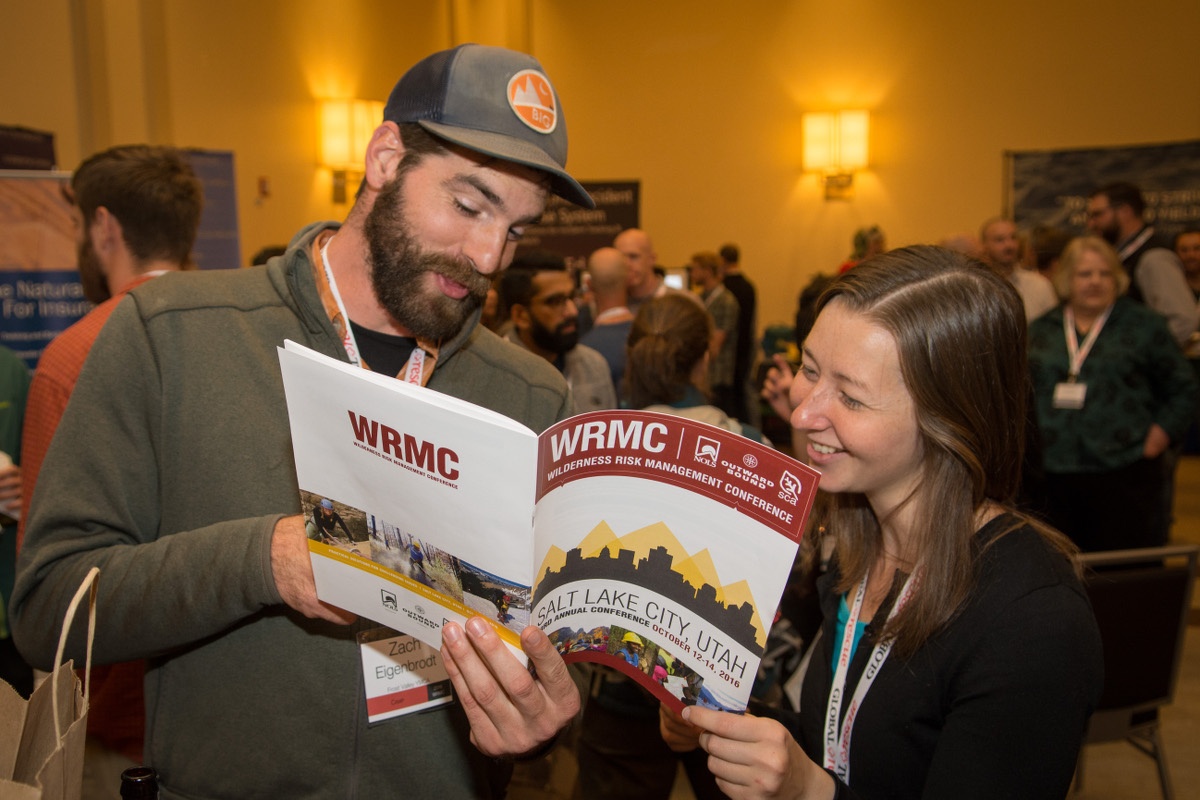 Two people look at at the program for the conference