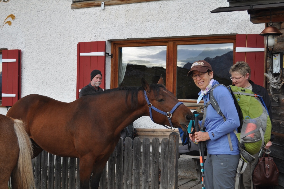 Kate Dernocoeur pets a horse while on a NOLS alumni trip