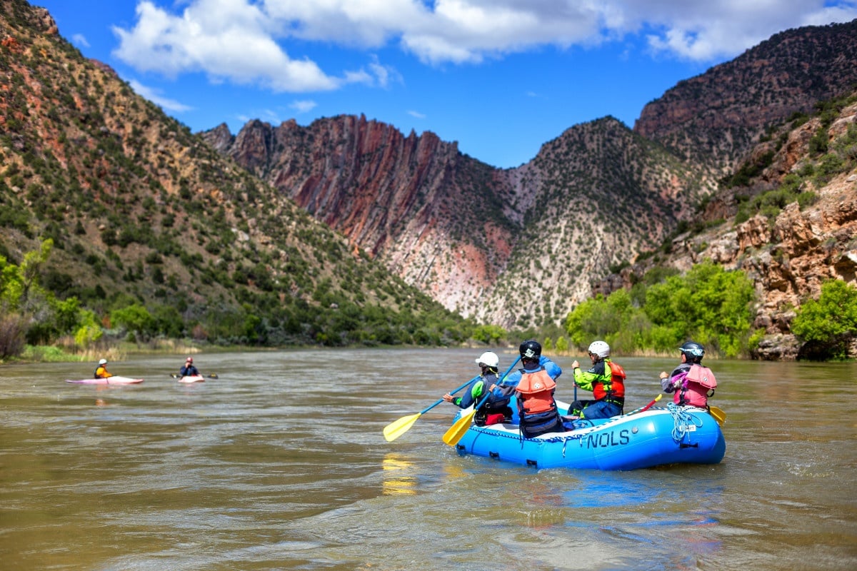 Group paddling a raft on a river