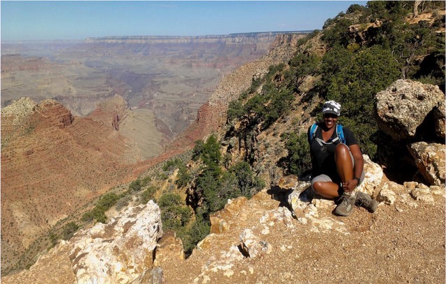 Day Scott sitting on a large pile of rocks with the Grand Canyon behind her in the background