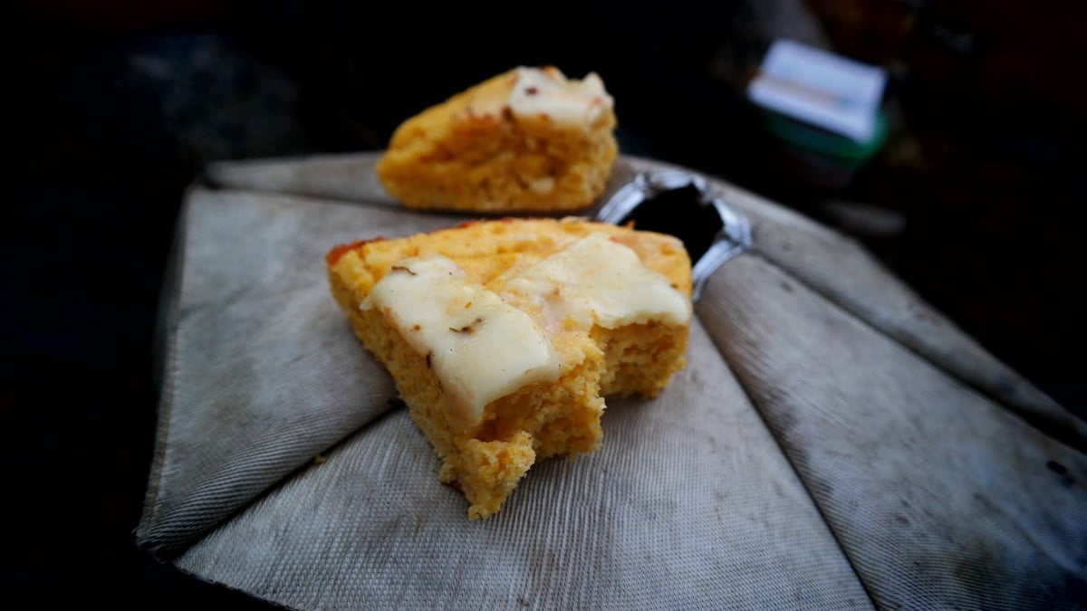 two pieces of cornbread with cheese on top