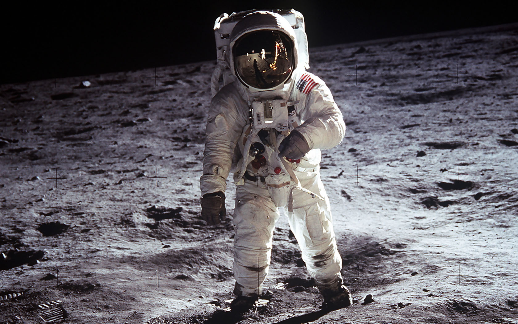 astronaut wearing spacesuit with U.S. flag walks on the moon