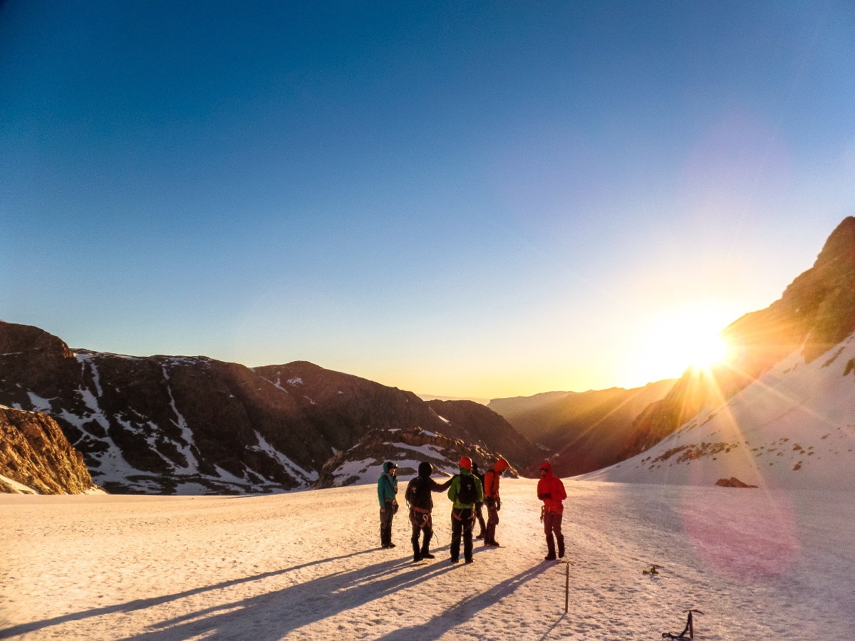 NOLS course on a snowfield at sunrise getting ready to summit Gannett Peak in Wyoming