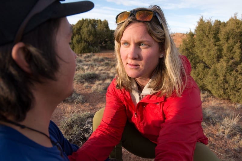 NOLS student kneels beside a mock patient, offering psychological support