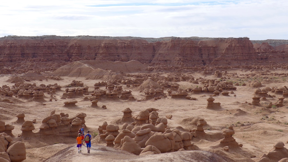 The boys hiking in a red rock landscape in Goblin Valley State Park