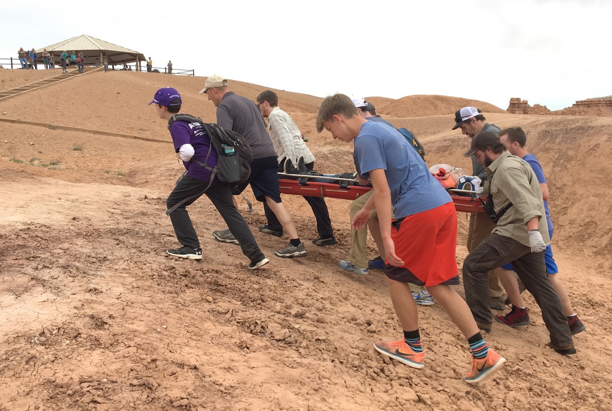 team of first responders work together to evacuate a patient on a stretcher