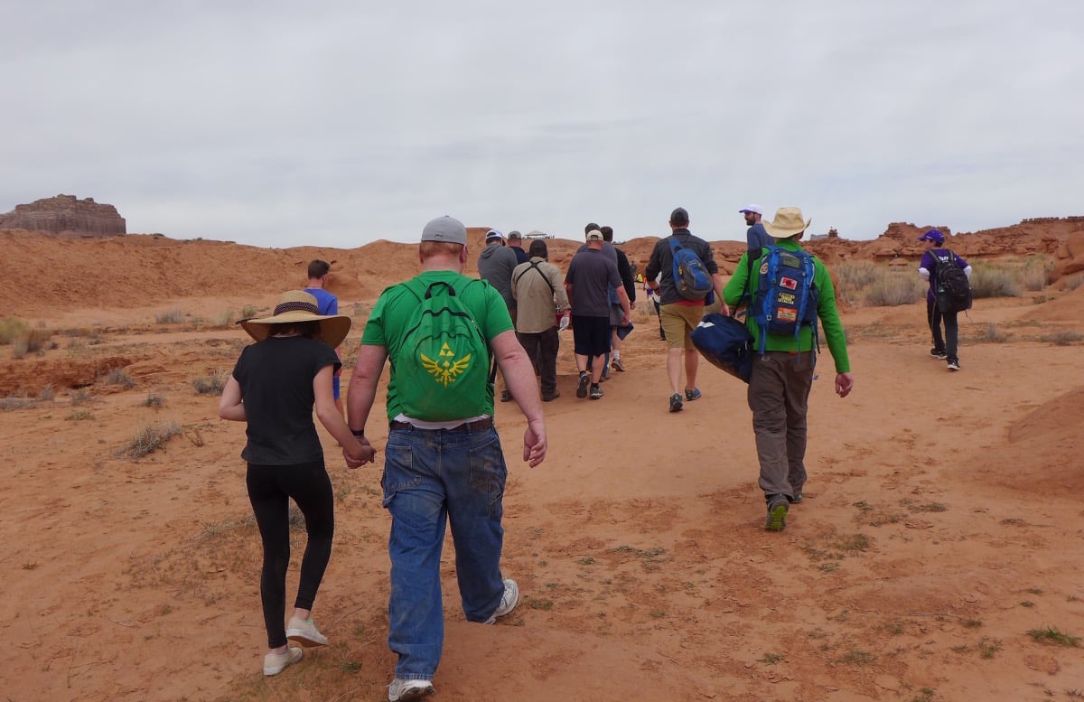 Group of people who helped rescue the patient walk across red sand in Goblin State Park