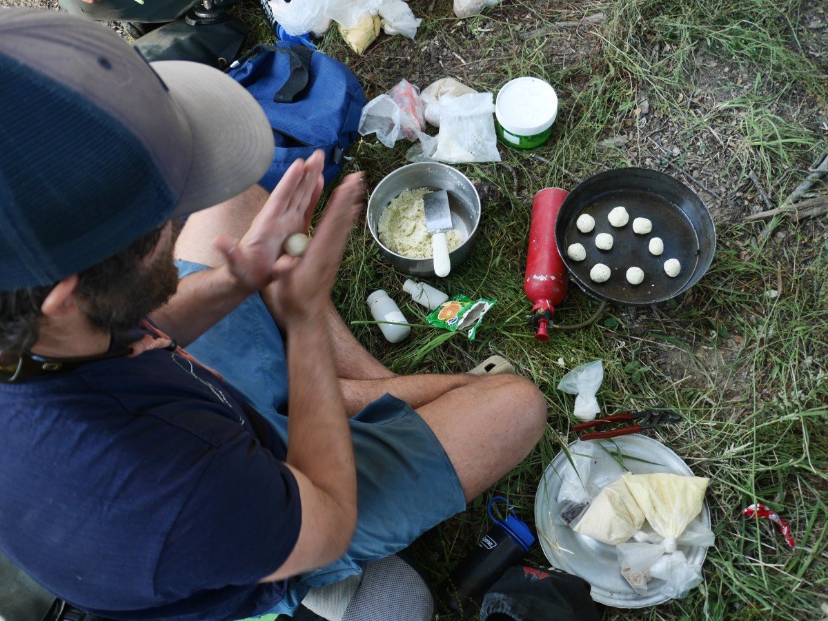 Teen preparing batter for biscuits on a camp stove