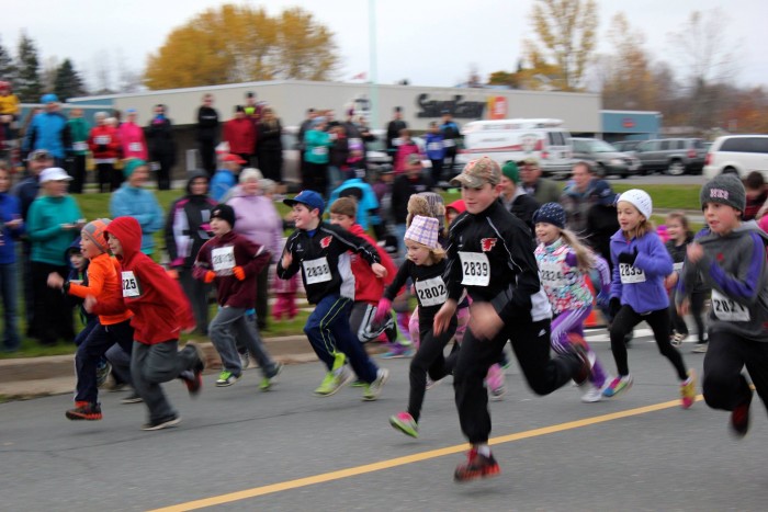 children wearing race bibs in a running race