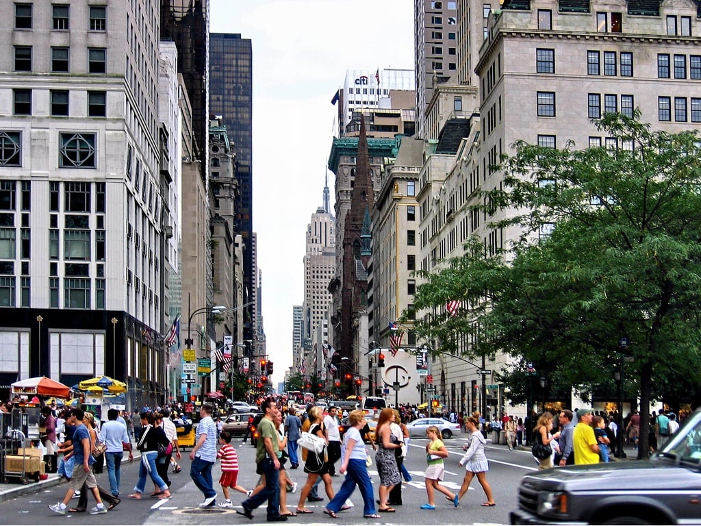 Busy city street with pedestrians crossing the street
