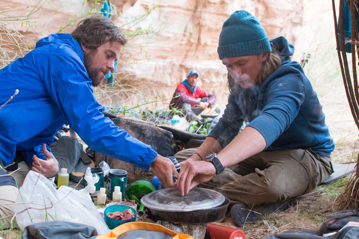 Two people cooking in a campsite kitchen