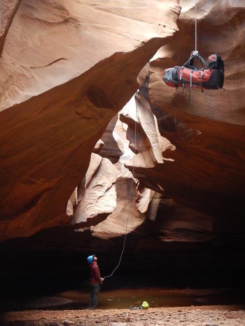 Lowering backpack into a slot canyon
