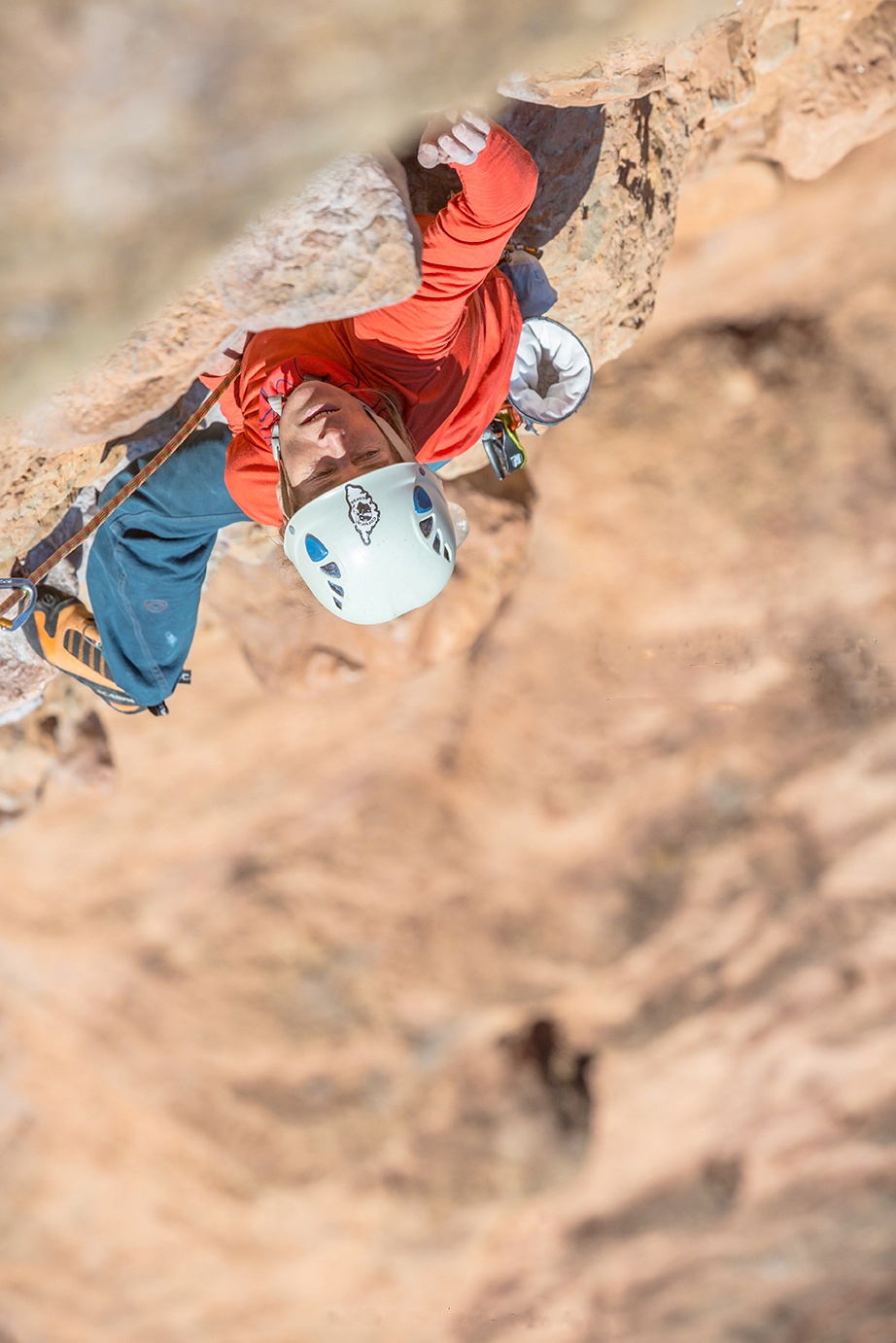 close-up taken from above of Lynn Hill climbing up reddish rock