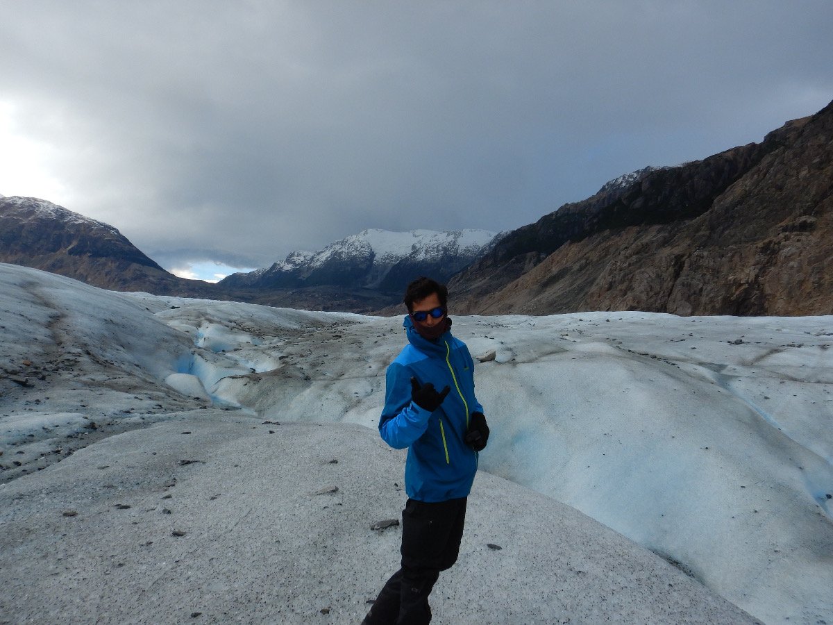 Person posing and looking at the camera standing on a glacier