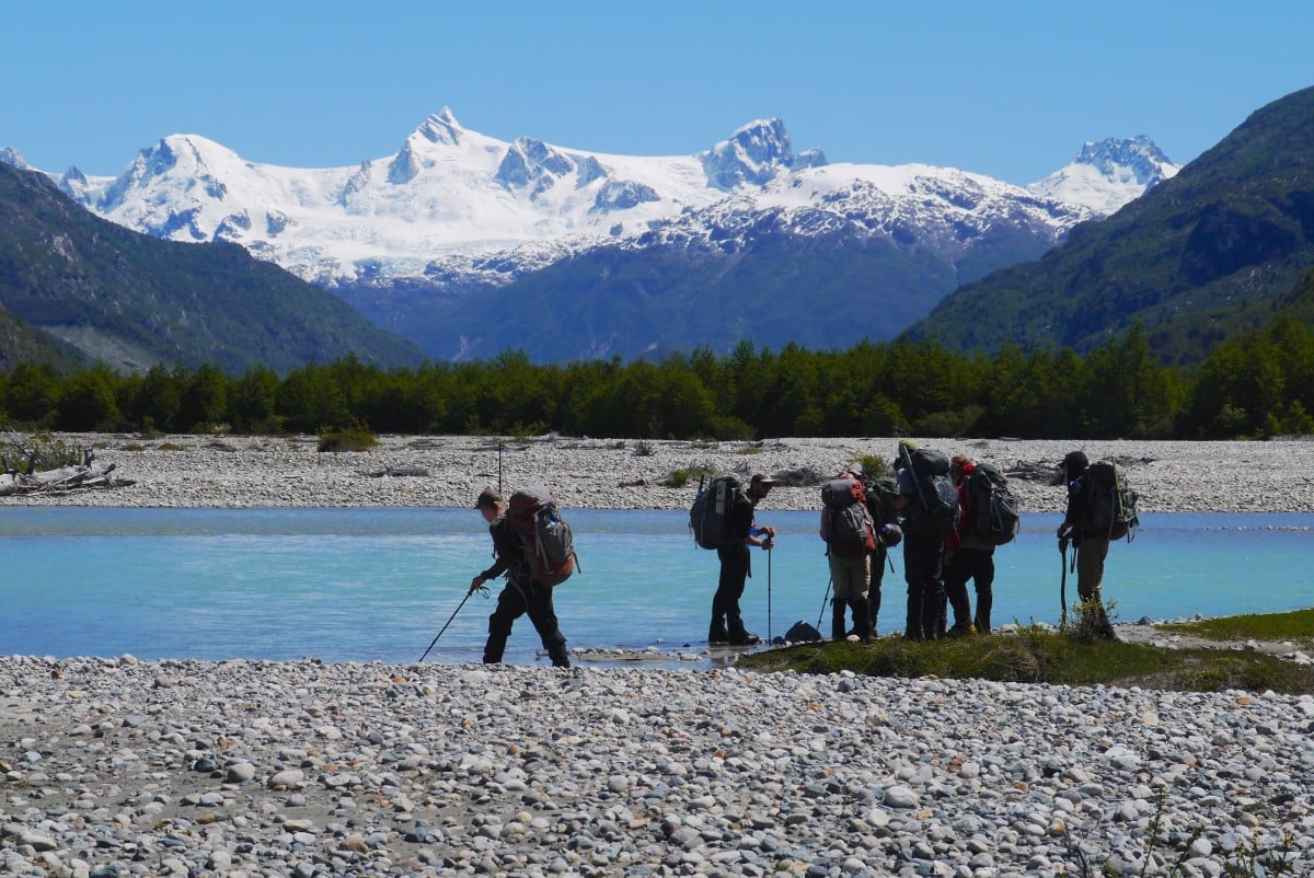 Hiking near a river with mountains in the distance