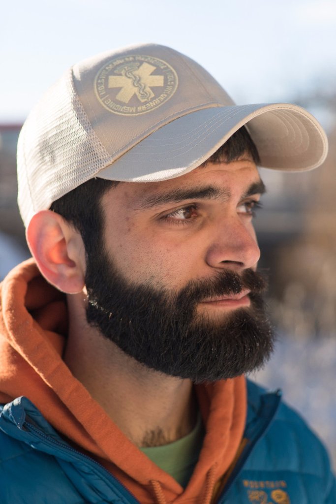 Person with beard wearing NOLS Wilderness Medicine hat