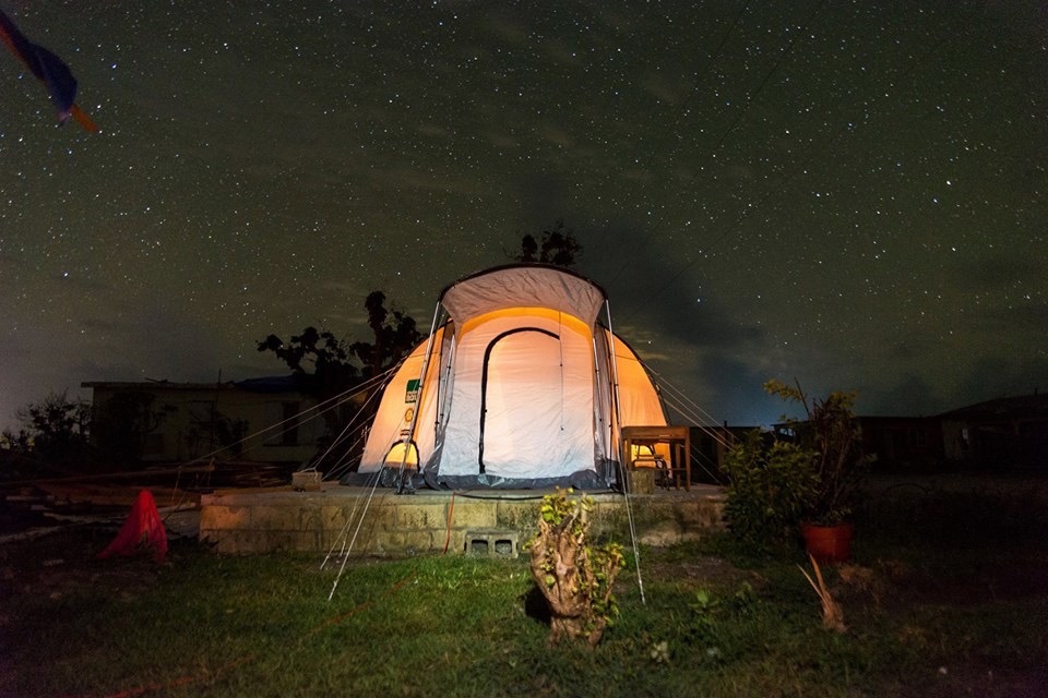 orange and grey tent lit up with solar light on a starry night