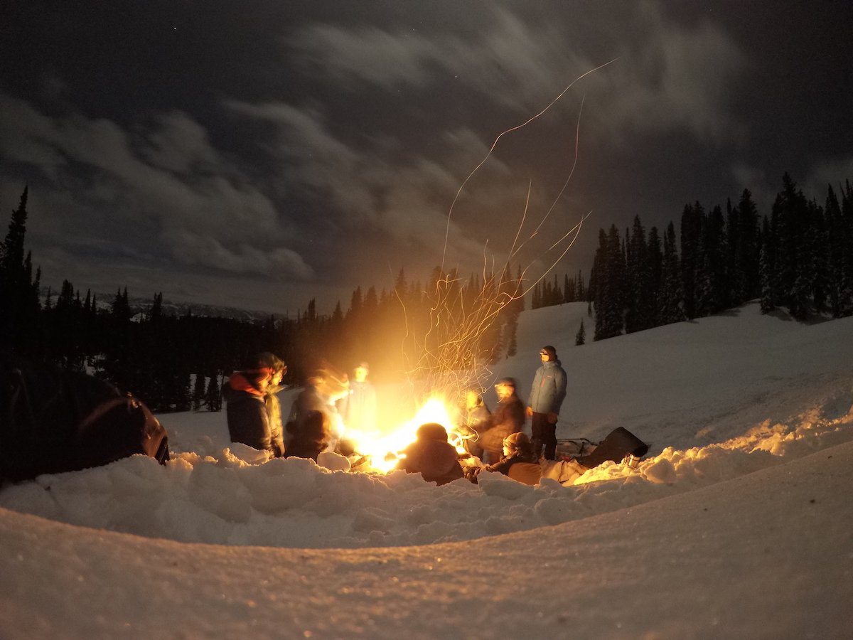 Group around a campfire at a winter campsite