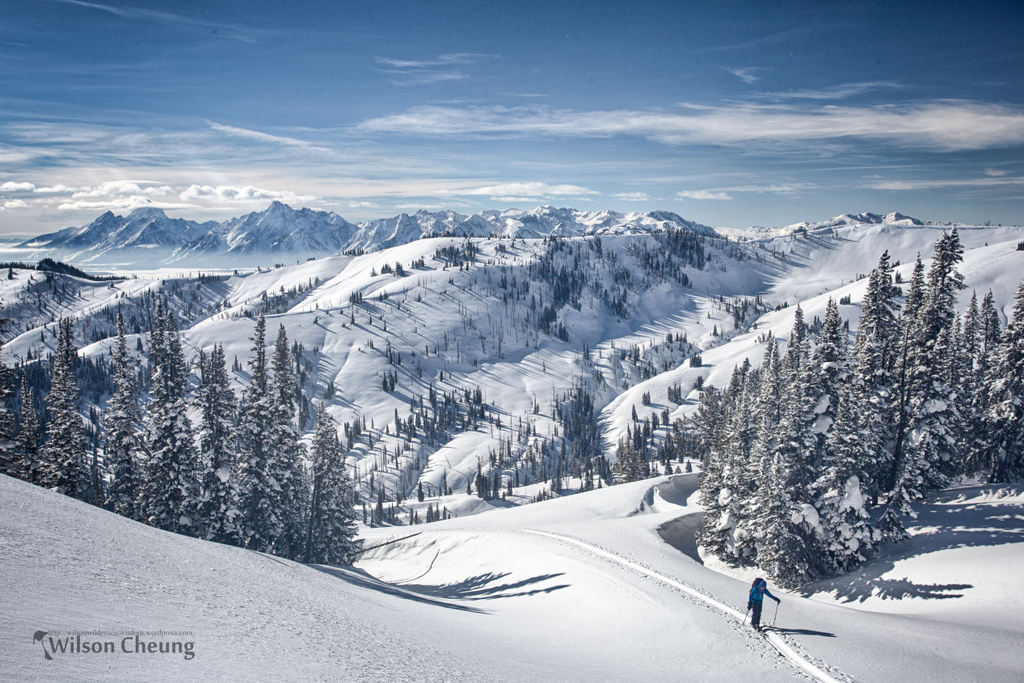 Person backcountry touring in winter landscape with Tetons in the background