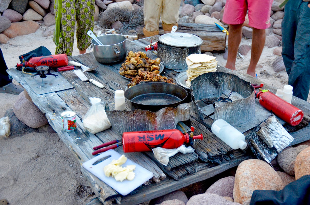 Table with cooking gear and stoves for camping