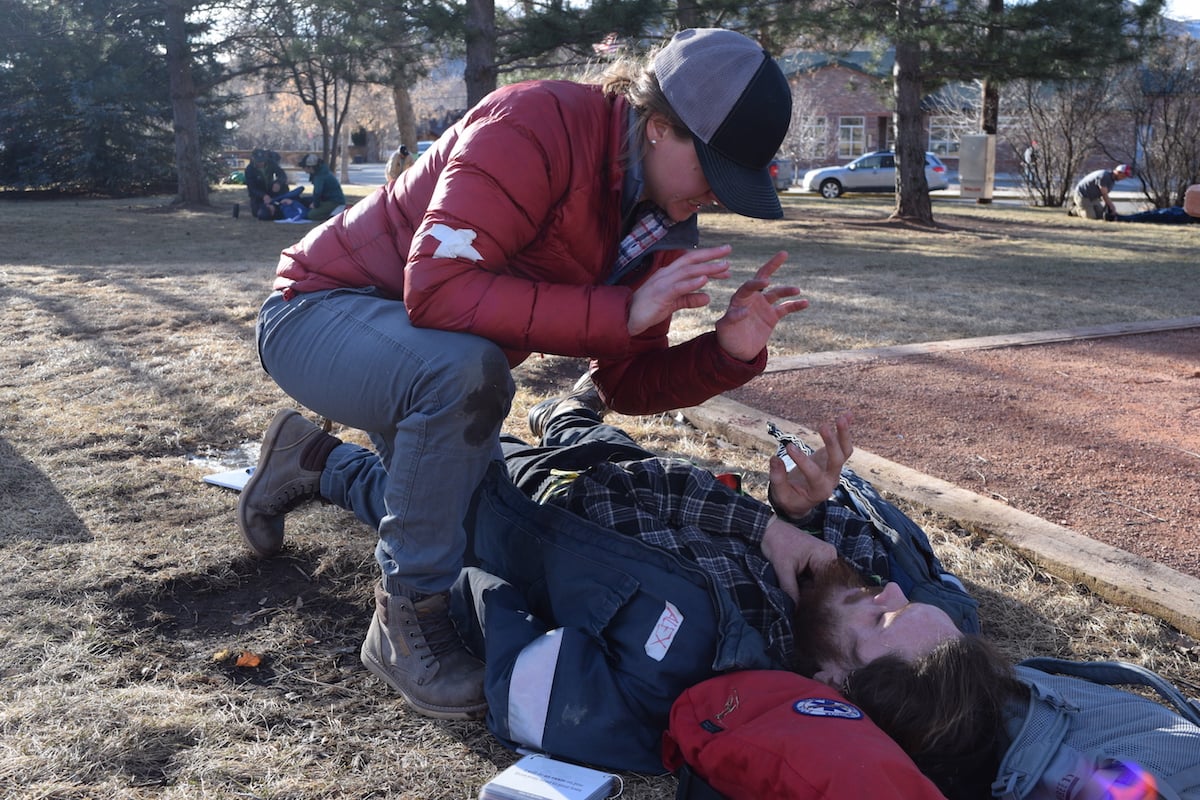 NOLS wilderness medicine students communicate in ASL while practicing patient care outdoors