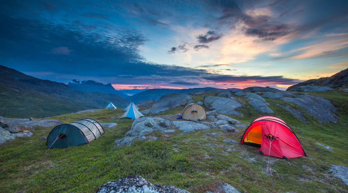 sunset over NOLS tents scattered between rocks in the mountains of Scandinavia