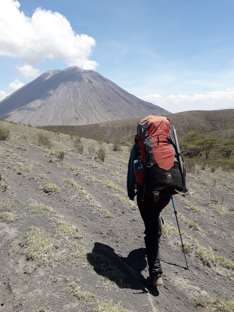 NOLS participant with backpack treks toward mountain