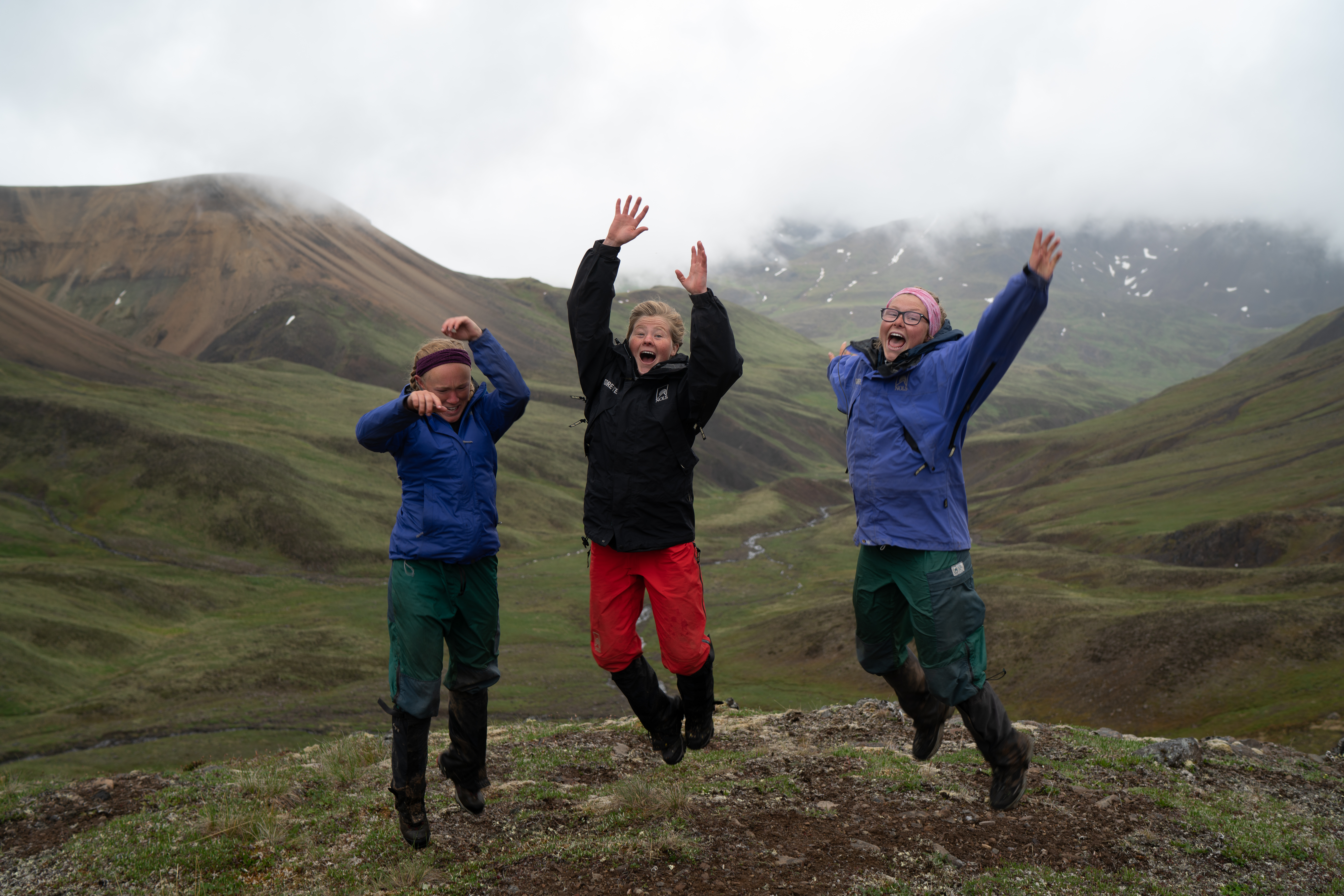Students jump in air in the the Alaskan mountains