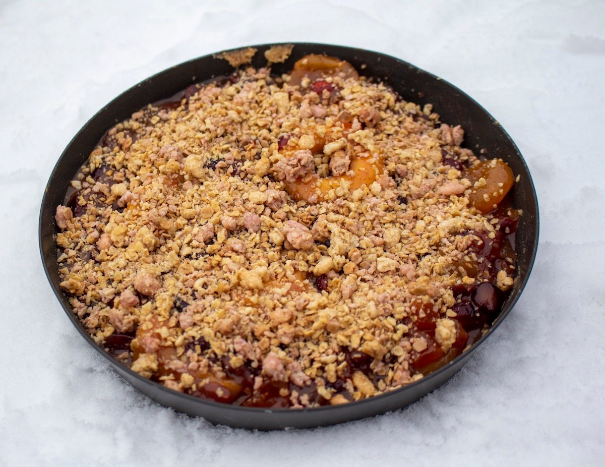 backcountry pie with garnished top sits in a frying pan in the snow