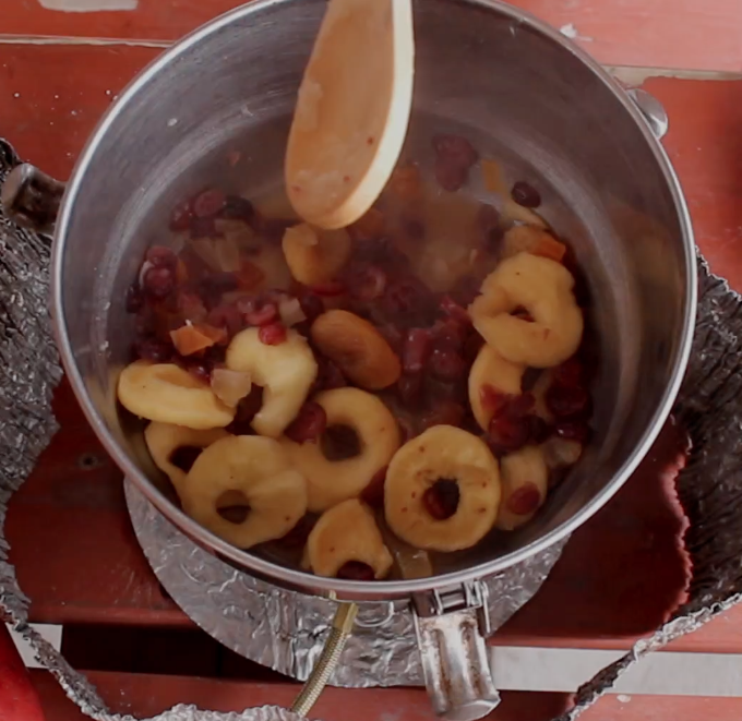 wooden spoon stirs re-hydrated dried fruit to make pie filling