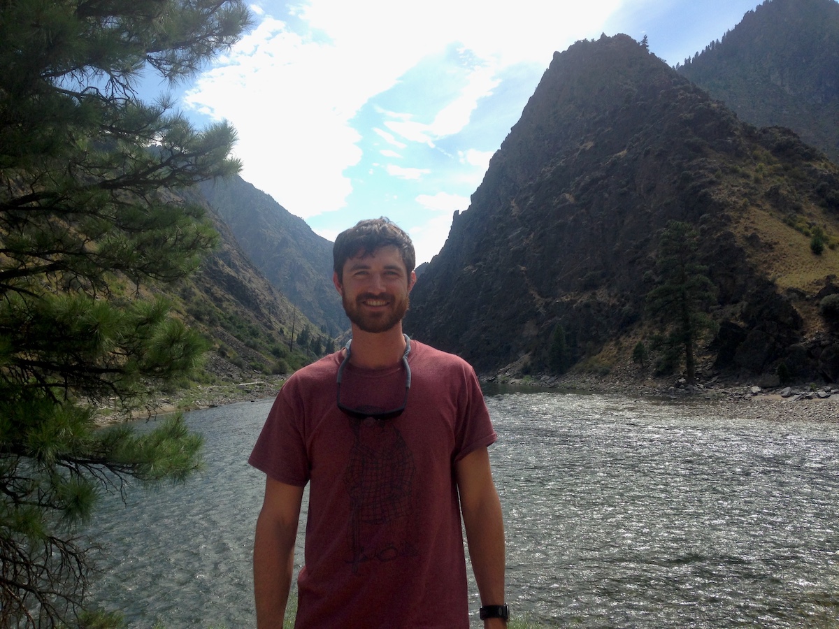 Person smiling in front of a lake