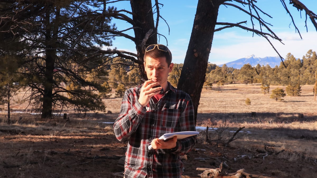 A rescuer calls in a SOAP note in a radio in the woods.