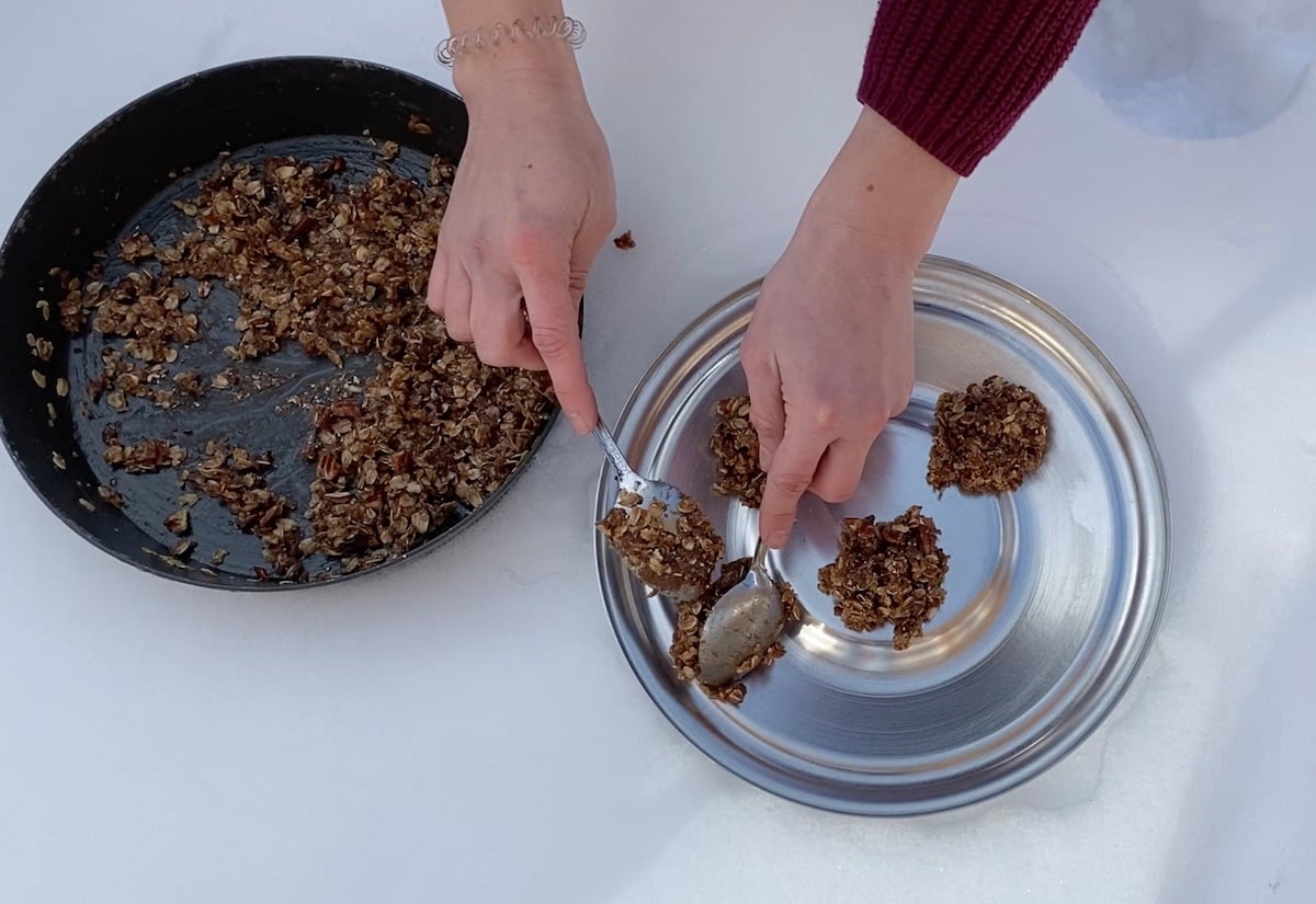 dropping spoonfuls of batter from a fry bake onto a tin lid