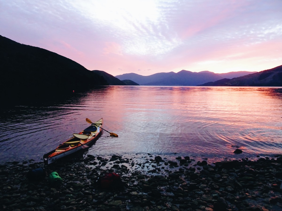 Kayak on a rocky beach at sunset