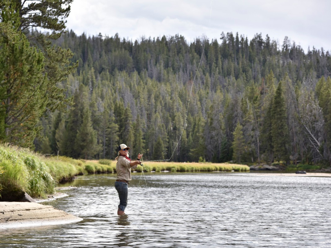 Woman fly fishing in a river